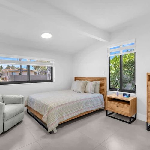 Bedroom 2 features a cozy queen-size bed, soft linens, plush pillows and a cozy reading chair ideal for catching up on your latest reads.
