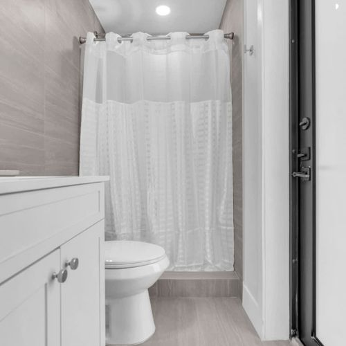 Enjoy a clean, generously sized bathroom with modern finishes and equipped with all the basics, including towels, toiletries essentials, and a convenient hair dryer.