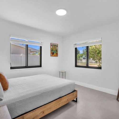 Wake up to natural light in this spacious modern Bedroom 3 featuring plush bedding, serene decor, and a bright open feel throughout the space.