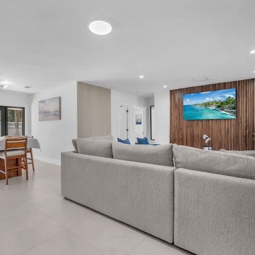 Clean modern interiors meet warm tropical touches in this airy living and dining area, complete with comfortable seating, sleek finishes, and a bright welcoming atmosphere.
