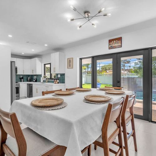 Enjoy breakfast, dinner, or late-night conversations in this welcoming dining space with natural light and relaxing pool views just steps away.
