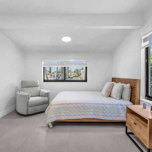 Bedroom 2 features a cozy queen-size bed, soft linens, plush pillows and a cozy reading chair ideal for catching up on your latest reads.