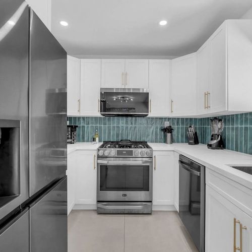 Cook comfortably in this modern kitchen complete with a large fridge, generous cupboard space, and sleek countertops perfect for everything from quick breakfasts to family-style meals.
