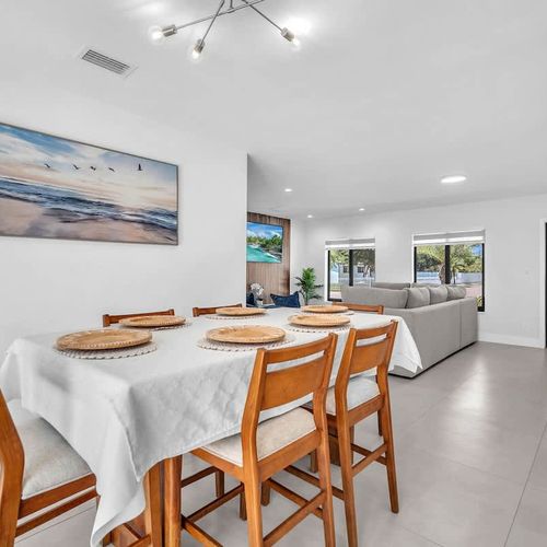Enjoy breakfast, dinner, or late-night conversations in this welcoming dining space with natural light and relaxing pool views just steps away.