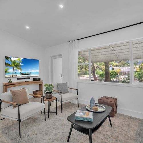 Stream your favorite shows on the large Smart TV in a stylish, light-filled living space surrounded by natural greenery.