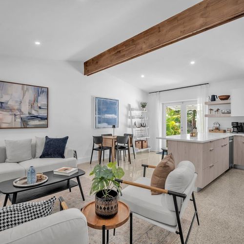 Bright, open-concept living room and kitchen flowing seamlessly out to the private tropical garden.