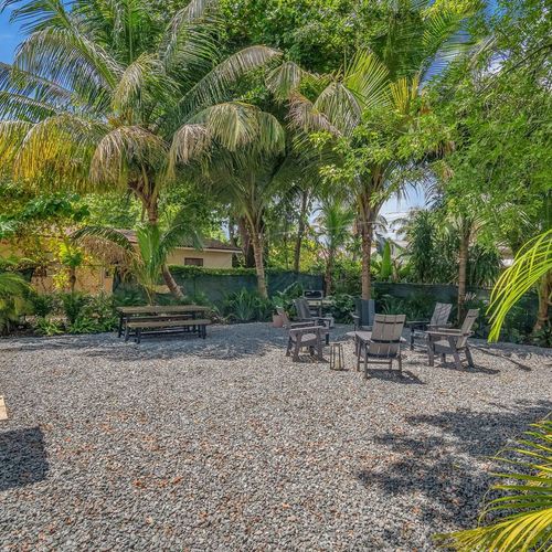 Tucked away under soaring palms and dense foliage, this peaceful outdoor setting offers a serene, natural getaway for morning coffee or relaxing afternoons or evenings.