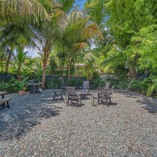 Tucked away under soaring palms and dense foliage, this peaceful outdoor setting offers a serene, natural getaway for morning coffee or relaxing afternoons or evenings.