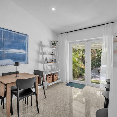 Sunlit breakfast corner seating four, offering front-row views of the lush greenery just steps outside.