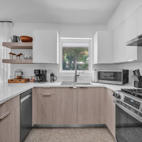 Fully functional kitchen equipped with a coffee bar, microwave, dishwasher, and easy access straight out to the backyard.
