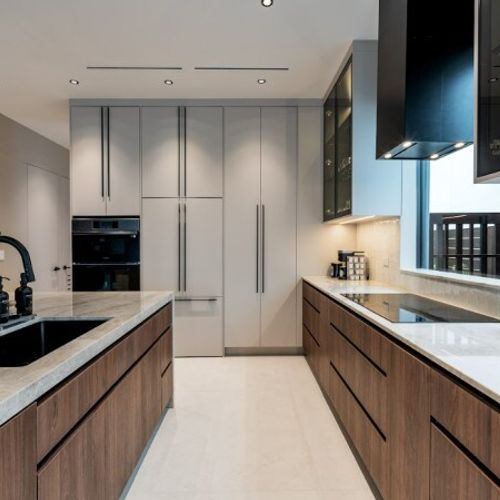 Experience a clean, architectural aesthetic with hidden handle-less drawers, a high-performance black range hood, and expansive workspace perfect for gourmet meal preparation.