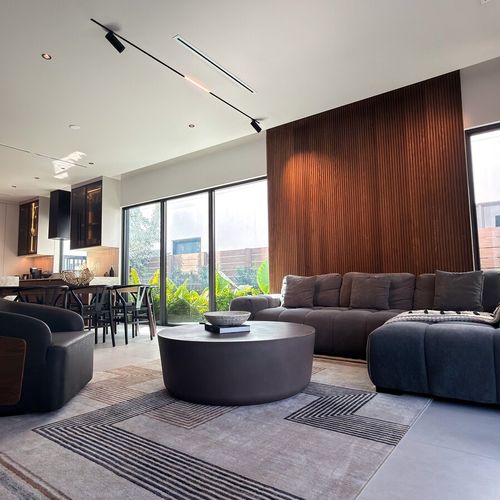 The living area features a super comfortable sectional sofa and a beautiful round coffee table, but the real highlight is the massive glass doors. Effortlessly connecting the inside space to the outdoors.