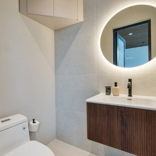 This bathroom is located in the pool area. Conveniently located for guests, this modern half bathroom blends sleek functionality with high-end style.