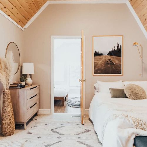Primary bedroom with bright light and woodsy views