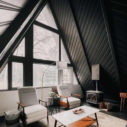 Living area with large windows (the wood-burning stove is decorative only and does not operate)