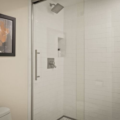 The bathroom has a walk-in glass shower