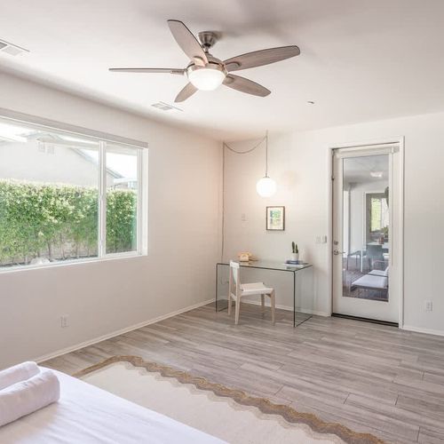 Primary bedroom with workspace and private patio exit