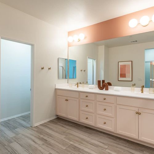 Dual vanities in the primary bedroom's full ensuite bathroom