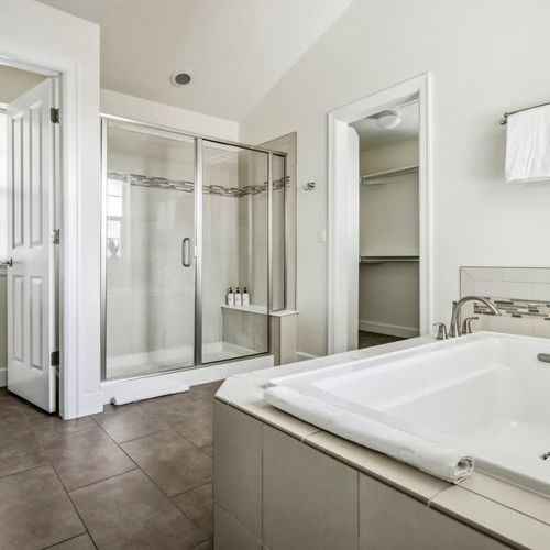 Primary en suite bathroom with shower and soaking tub
