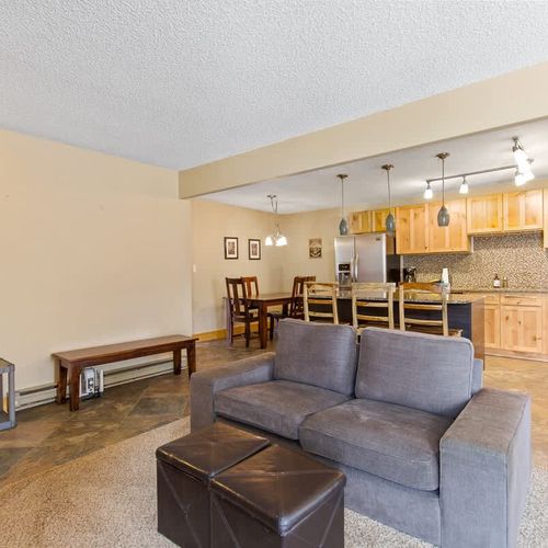 Seating in front of the wood-burning fireplace and open kitchen