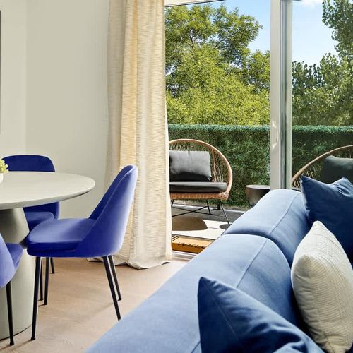 Living and dining area lead to private balcony