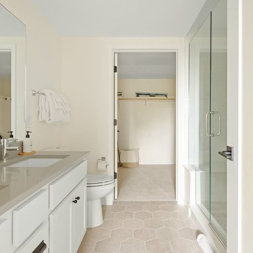 Primary en suite bathroom leads to walk in closet