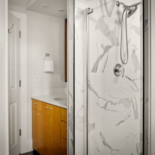 Large walk-in glass shower in primary en suite bathroom