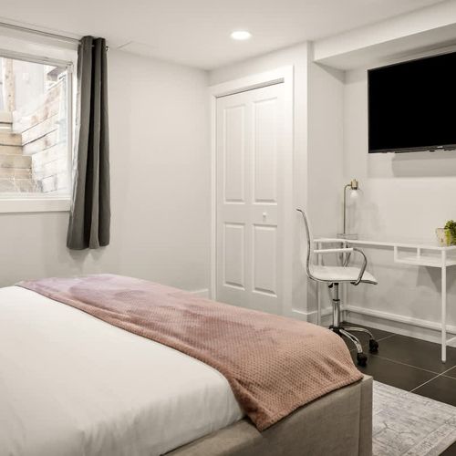 Basement bedroom has a Smart TV and work space