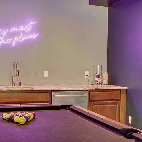 Pool table and neon sign in game room
