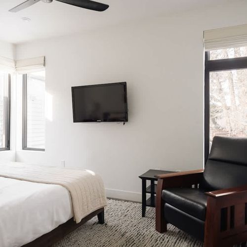 Primary bedroom with king bed, flatscreen TV, and seating area