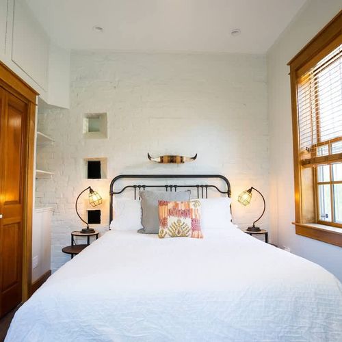 The bedroom features a queen bed, as well as a closet and dresser for ample storage space.