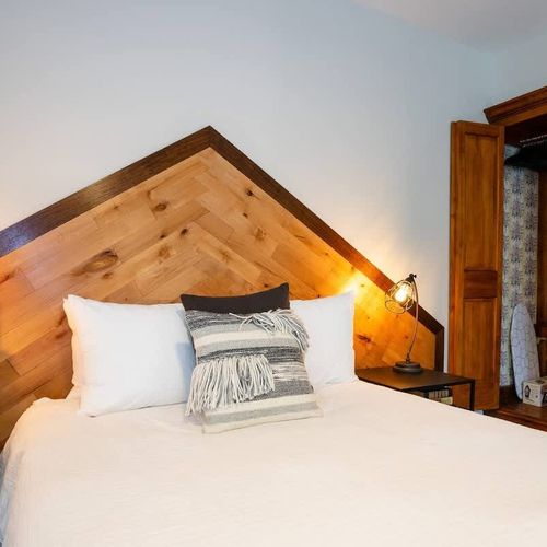 The room includes a wardrobe, as well as an iron + ironing board