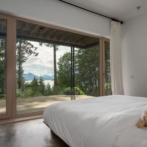 The primary suite with floor to ceiling windows and incredible views.