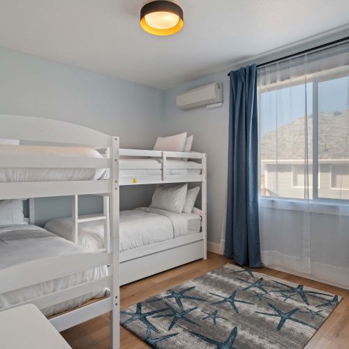 Bunk room has soft rugs, extra light, and plenty of room for games or bags.