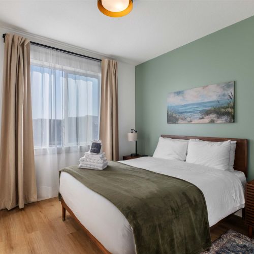 Second queen bedroom with relaxing colors and natural light.