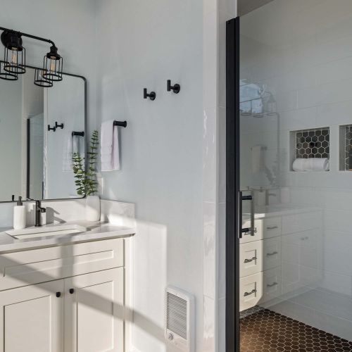 Large shower, two sinks, and clean finishes—shared by two of the bedrooms.