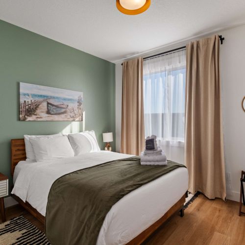 Comfortable queen bedroom with light-blocking curtains and modern design.