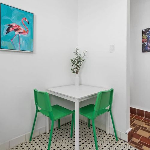 Relax and unwind in our stylish room, featuring a pristine white table perfect for enjoying meals or working in comfort.