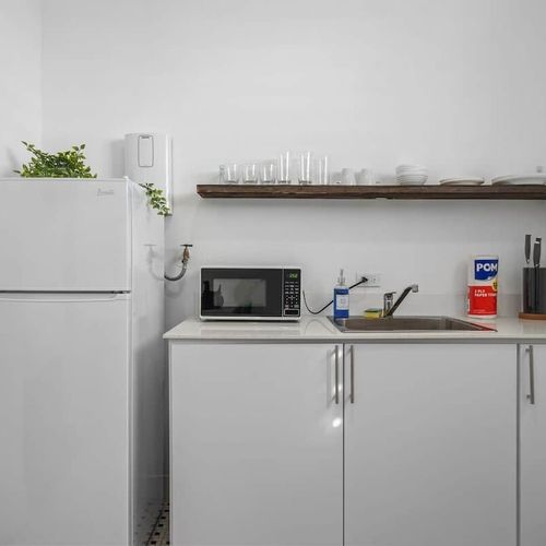 Discover culinary inspiration in our sleek white kitchen, where modern design meets functionality for your cooking pleasure.