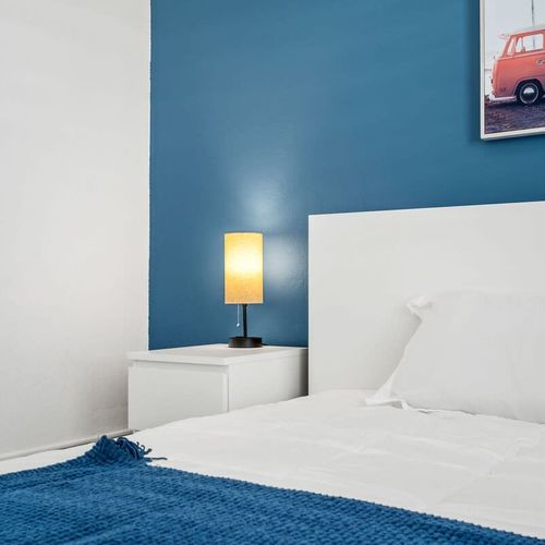 Rest easy in this well-appointed bedroom featuring modern amenities, artistic touches, and a calming color palette for your ultimate relaxation.