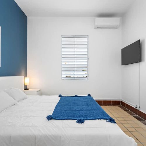 Enjoy sweet dreams in our plush bed set against the backdrop of vibrant walls adorned with eclectic art – an oasis of comfort awaits!