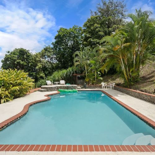 Inviting big pool with lush greenery and a mountain view.