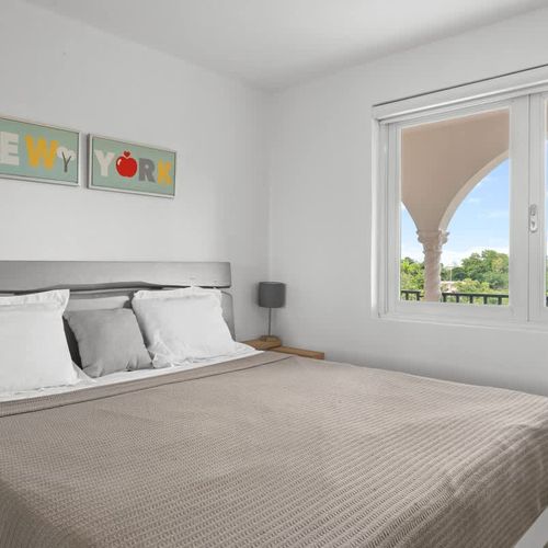 An inviting bedroom with a plush bed and cozy throw blanket.