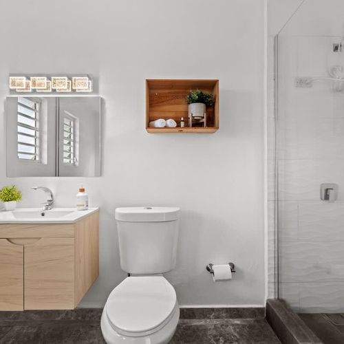 clean an minimalist bathroom with rainshower, comfortable white wc, modern sin with mirror and good lighting