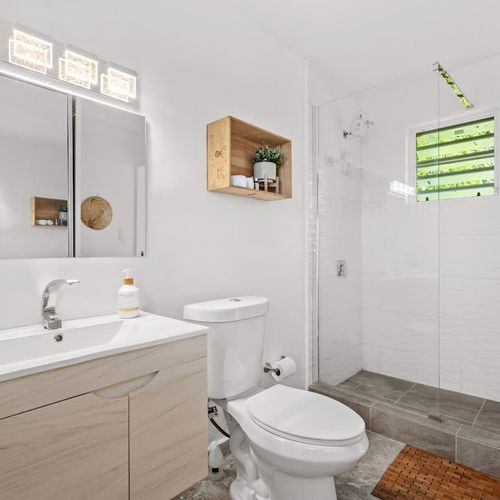 Clean a minimalist bathroom with rainshower, comfortable white wc, modern sin with mirror and good lighting