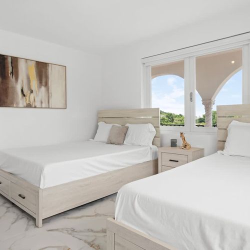 A modern bedroom with minimalist decor and marble flooring.
