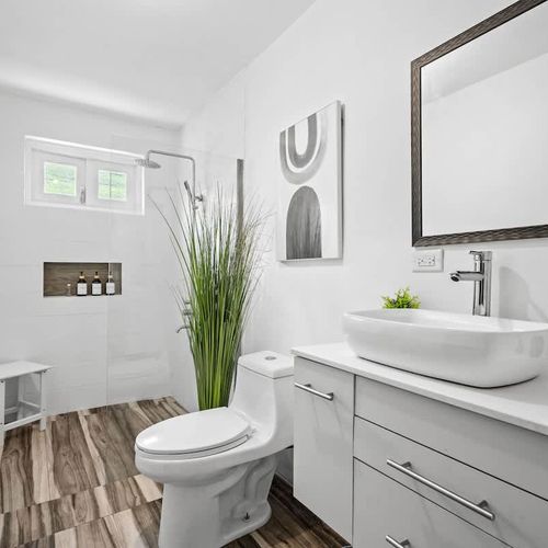 A well-lit bathroom featuring a large mirror.