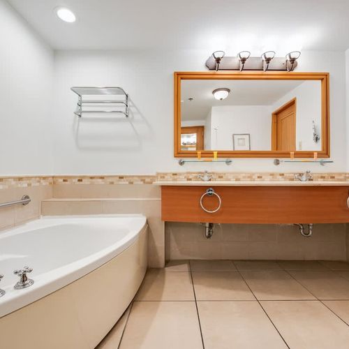 Bright and spacious, our bathroom offers a sophisticated design with beautiful tile accents and a large, well-lit mirror to get ready in comfort.
