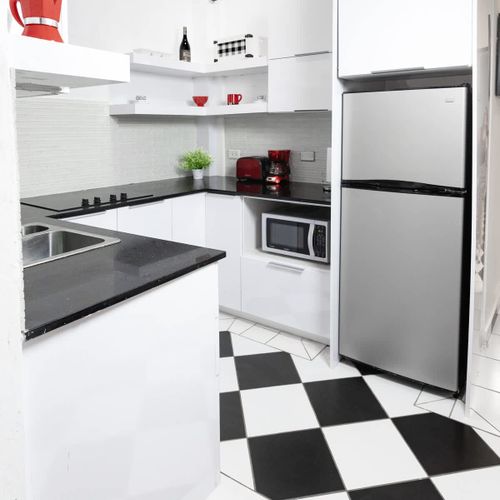Cook and dine with ease in the modern and well-equipped kitchen. The clean and stylish checkered floor tiles, ample counter space, and stainless steel appliances make meal preparation a delight during your stay.