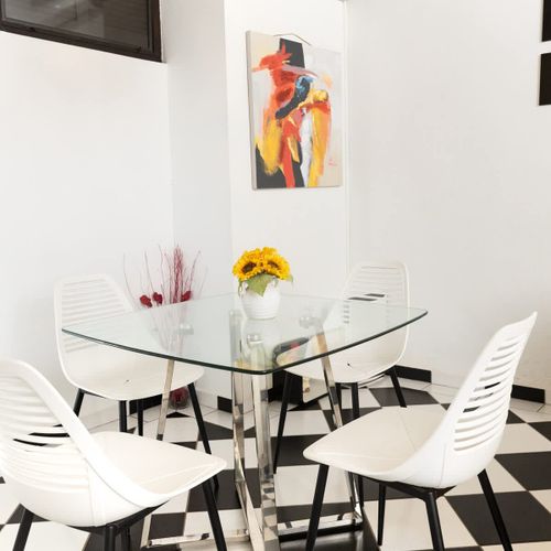 Gather for delightful meals in this charming dining area. The unique artwork adds a pop of color and personality to the space, creating an inviting atmosphere for shared moments and culinary enjoyment.